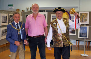 Photo of Mayor Cllr Paul Holbrook at the Hailsham Photographic Society's Print Exhibition (2023) - pictured with Society Chair Bruce Broughton and Town Crier Terry Tozer