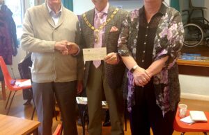 Phot of Town Mayor Cllr Paul Holbrook presenting donation cheque to Charles Hunt Centre Chair Alan Faulkner and Manager Sally Stanton