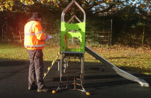 Photo of a play area inspection taking place in Stroma Gardens by one of the Town Council's Maintenance Operatives